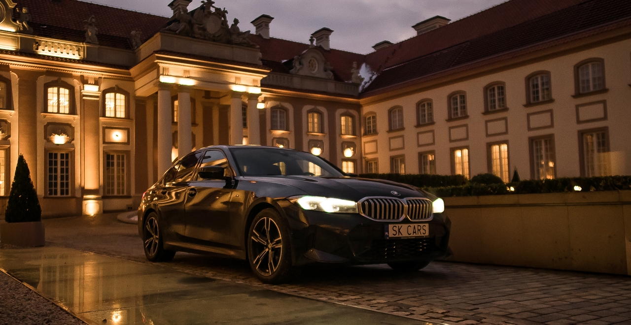 BMW Series 3 w wieczornym oświetleniu pałacu — idealny wybór na stylową podróż z SK Cars.