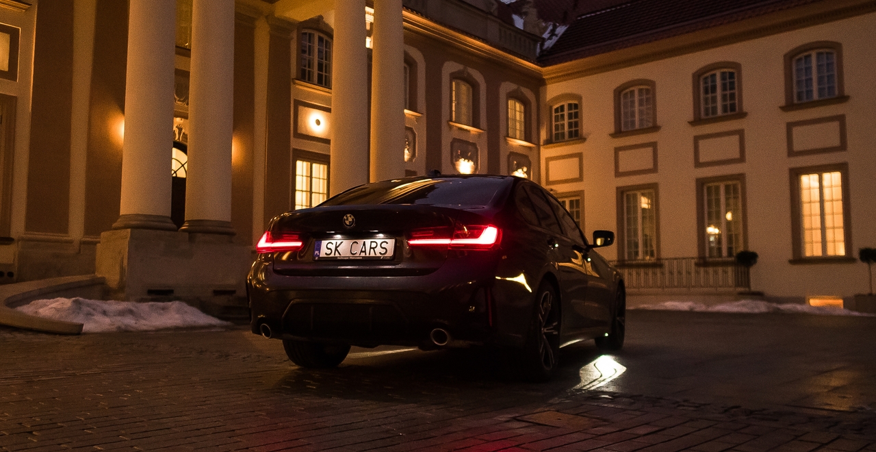 BMW 3 Series na tle luksusowego budynku wieczorową porą — połączenie elegancji i stylu. Zarezerwuj na stronie SK Cars.