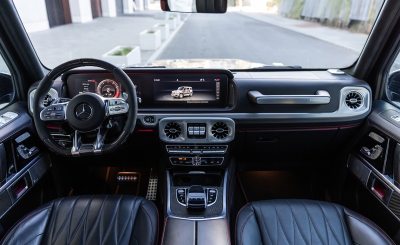 Wnętrze Mercedes-AMG G63 z tapicerką skórzaną, sportową kierownicą i cyfrowym ekranem G-Class.
